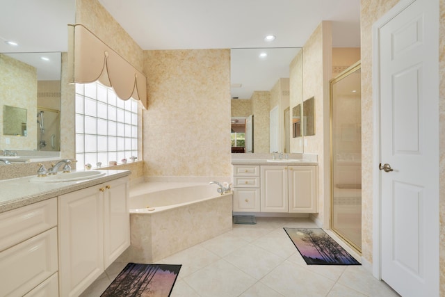 full bathroom with a stall shower, a garden tub, a sink, and tile patterned floors