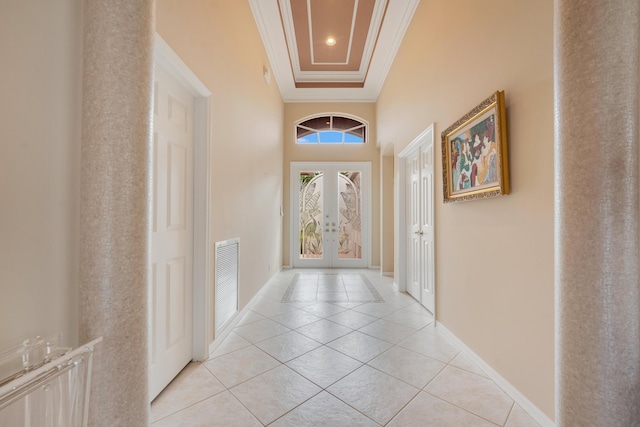 hall with light tile patterned flooring, visible vents, baseboards, french doors, and crown molding