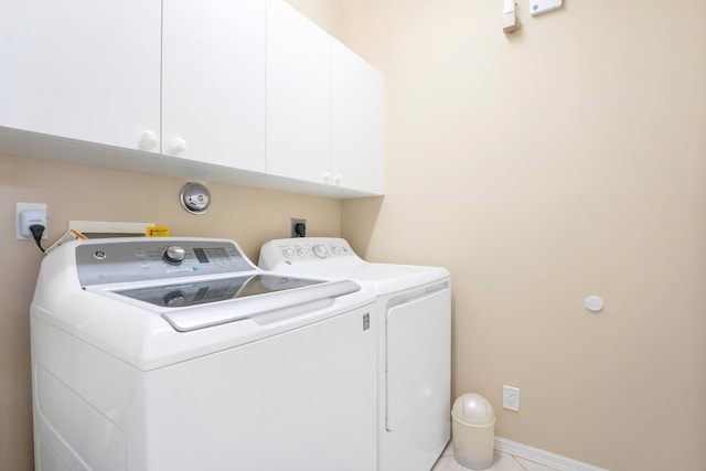 laundry area with washing machine and clothes dryer, cabinet space, and baseboards