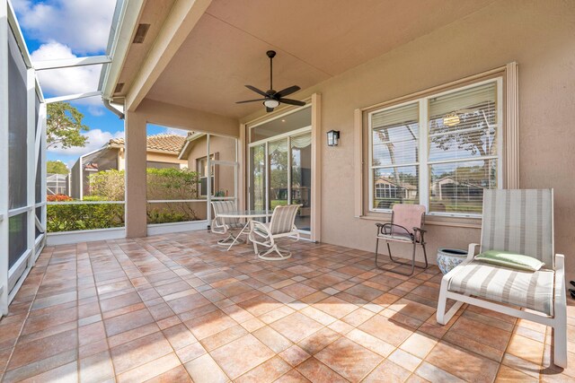 view of patio / terrace featuring glass enclosure and a ceiling fan