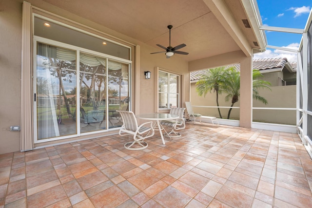 view of patio / terrace featuring glass enclosure and ceiling fan