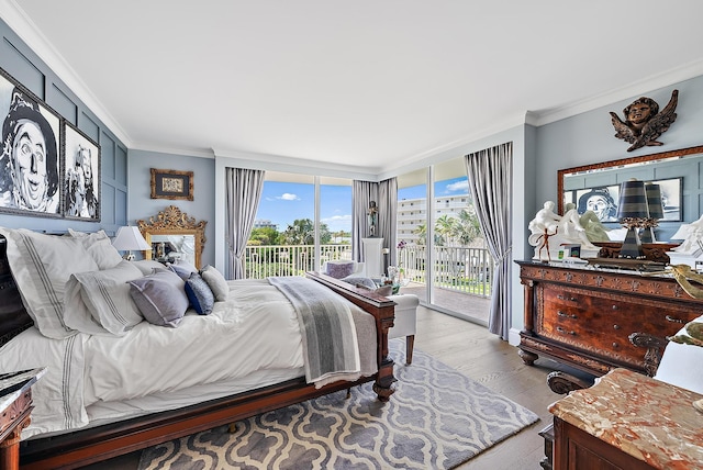 bedroom with access to outside, ornamental molding, and wood finished floors