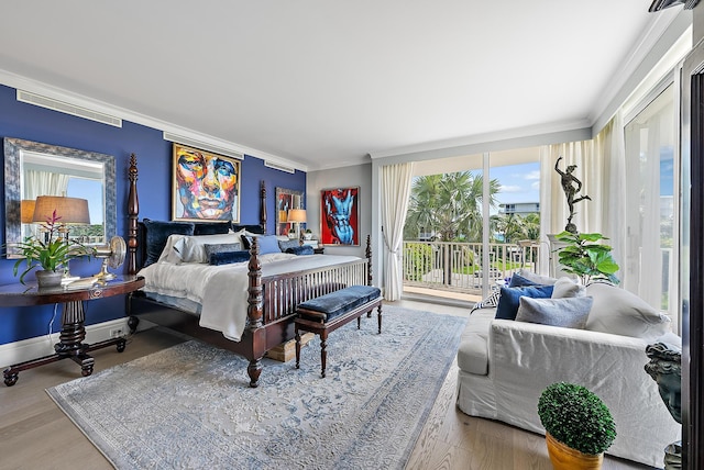 bedroom featuring crown molding, wood finished floors, visible vents, and access to exterior