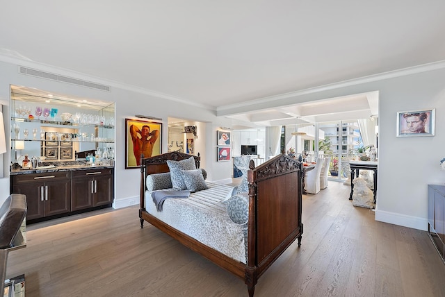 bedroom with indoor bar, crown molding, visible vents, light wood-type flooring, and baseboards