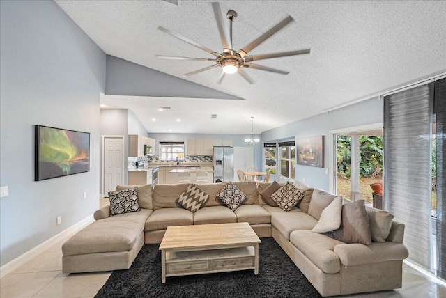 living room with vaulted ceiling, light tile patterned floors, a textured ceiling, and baseboards