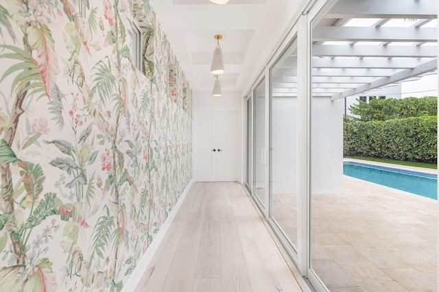 hallway with wallpapered walls and wood finished floors