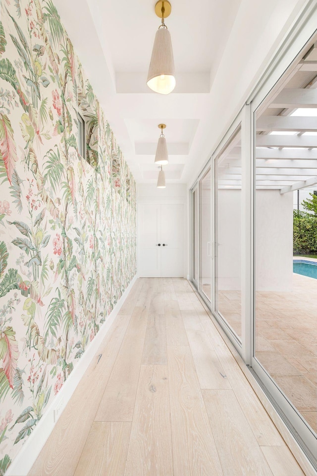 hallway featuring a tray ceiling and wood finished floors