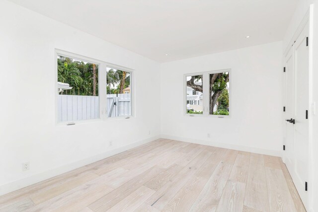 empty room with light wood-style flooring, baseboards, and recessed lighting