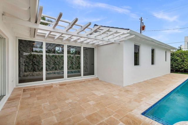 exterior space with a pergola, a patio area, an outdoor pool, and stucco siding