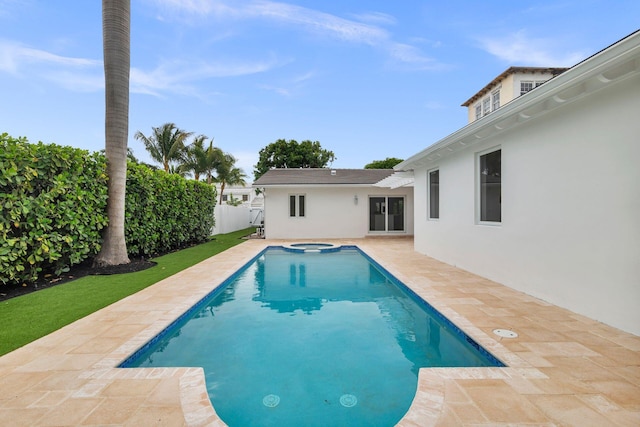 view of pool with a pool with connected hot tub, a patio area, and a fenced backyard