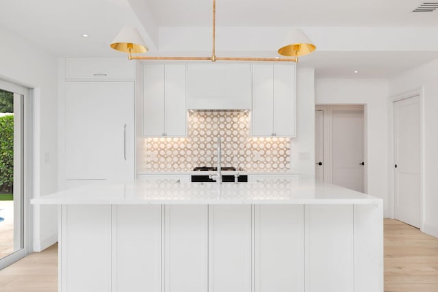 kitchen with visible vents, light countertops, backsplash, and white cabinetry