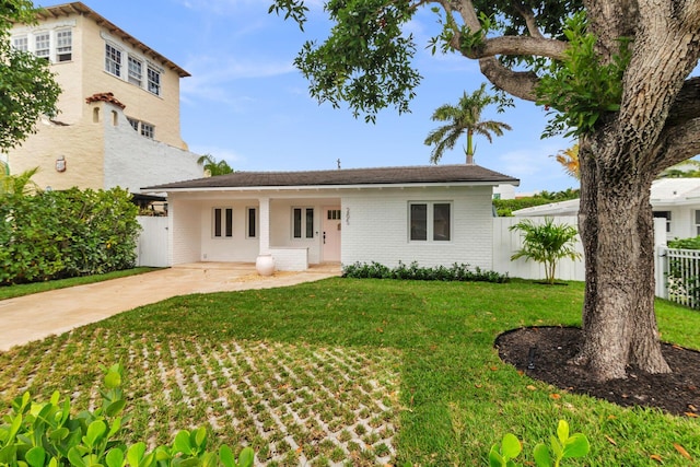 view of front of house with brick siding, a front lawn, and fence