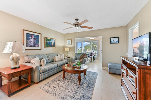 living room featuring baseboards, a ceiling fan, and light tile patterned flooring