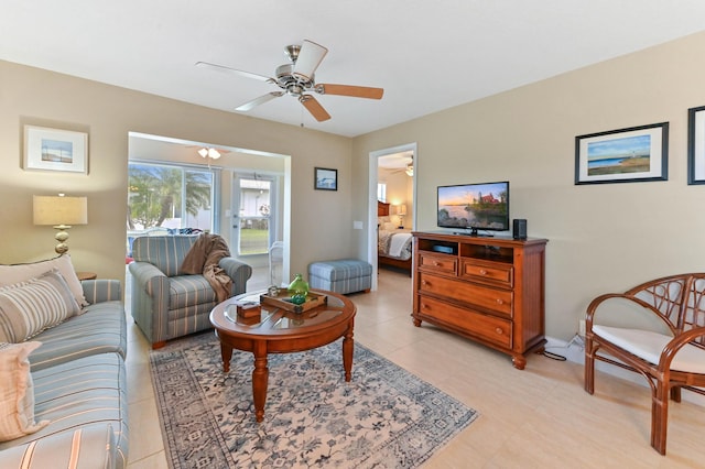 living room featuring light tile patterned floors, baseboards, and ceiling fan