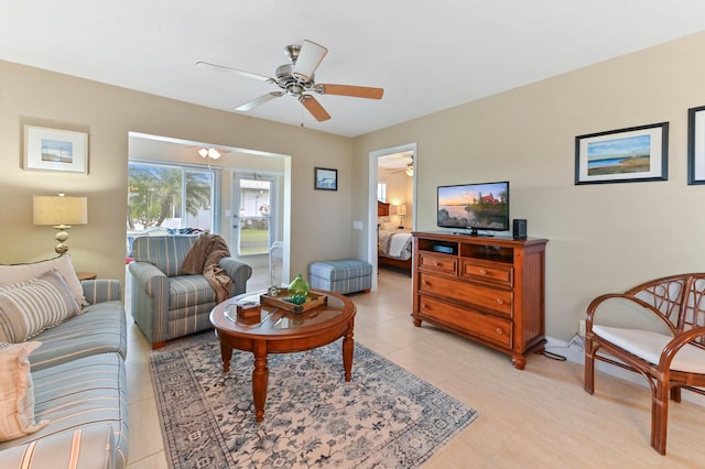 living area with light tile patterned floors and a ceiling fan