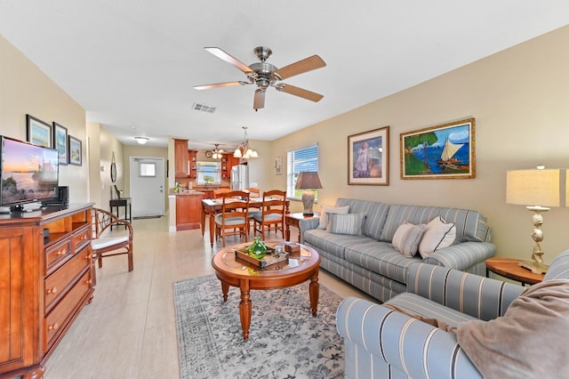 living area featuring light tile patterned floors, ceiling fan, and visible vents