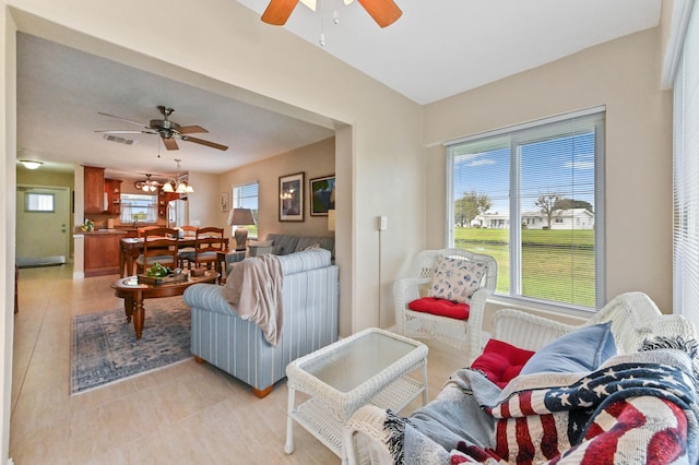 living area featuring light tile patterned floors, visible vents, and a ceiling fan