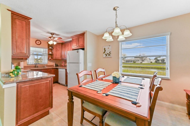 dining space featuring baseboards and ceiling fan with notable chandelier