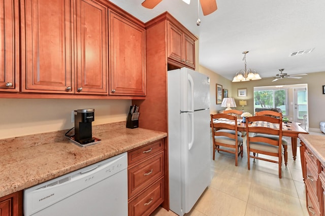 kitchen featuring ceiling fan with notable chandelier, white appliances, visible vents, light stone countertops, and brown cabinetry