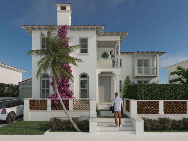 mediterranean / spanish-style home with a chimney, fence, a balcony, and stucco siding