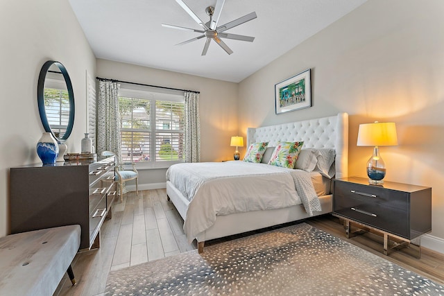 bedroom with ceiling fan, baseboards, and wood finished floors