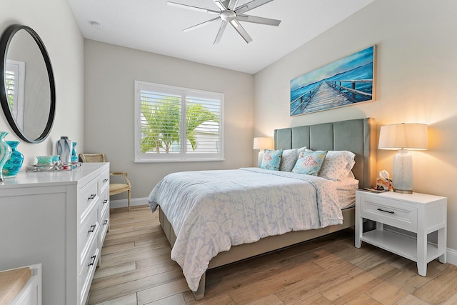 bedroom with light wood-style flooring, baseboards, and ceiling fan