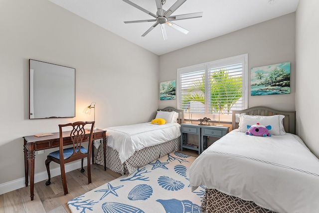 bedroom featuring lofted ceiling, ceiling fan, baseboards, and light wood-style floors