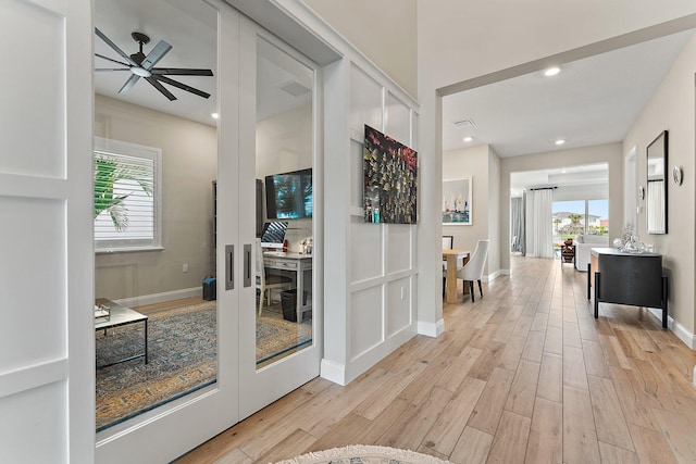 hallway featuring light wood-type flooring, plenty of natural light, and recessed lighting