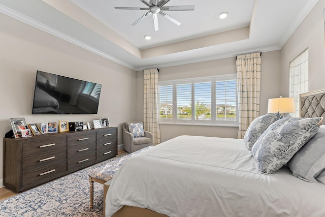 bedroom featuring ornamental molding, a raised ceiling, ceiling fan, and wood finished floors