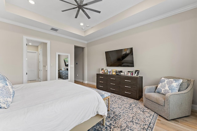 bedroom with light wood finished floors, a raised ceiling, visible vents, and recessed lighting