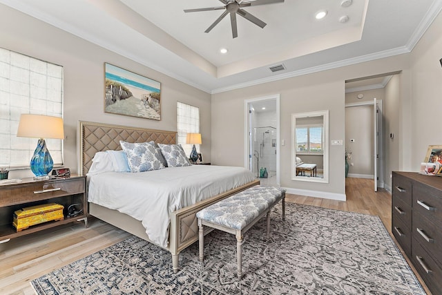 bedroom featuring visible vents, a raised ceiling, baseboards, light wood-style flooring, and ornamental molding