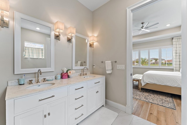 ensuite bathroom with a healthy amount of sunlight, ceiling fan, and a sink