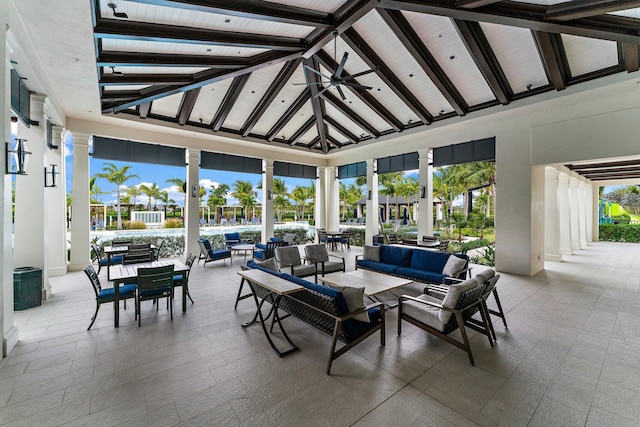 sunroom featuring vaulted ceiling with beams and ceiling fan