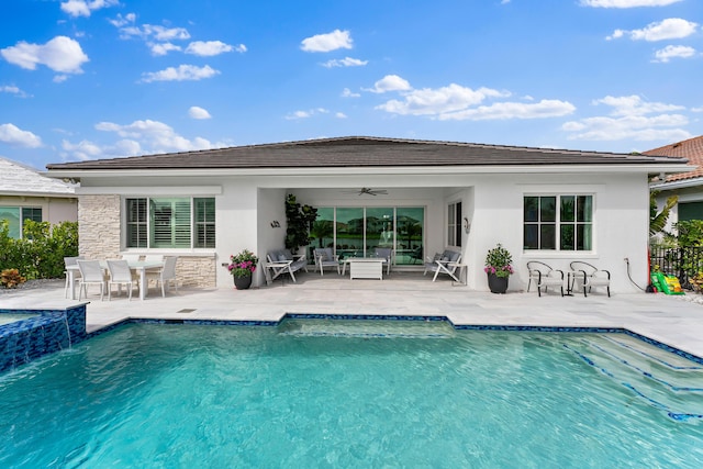 rear view of property featuring a ceiling fan, an outdoor pool, a patio, and fence