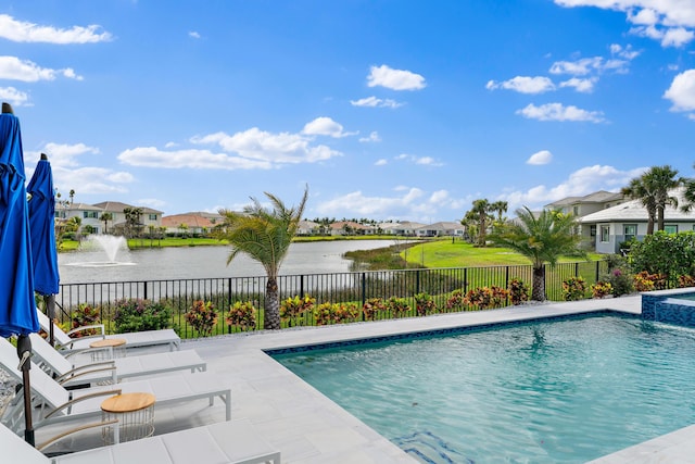 view of pool featuring a patio area, a fenced backyard, a residential view, and a water view