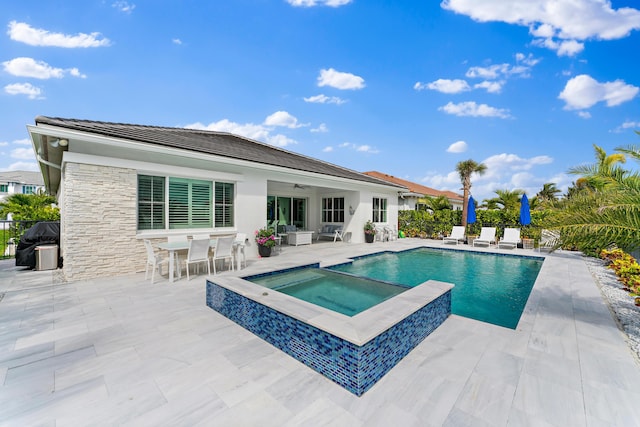 view of swimming pool with a ceiling fan, a patio area, fence, and an in ground hot tub