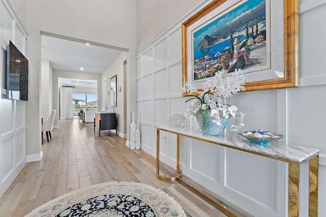 hall featuring light wood finished floors and baseboards