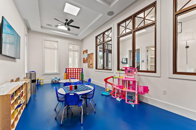 rec room featuring ceiling fan, baseboards, visible vents, and a raised ceiling