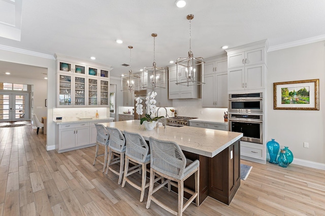 kitchen featuring tasteful backsplash, glass insert cabinets, crown molding, stainless steel double oven, and a sink