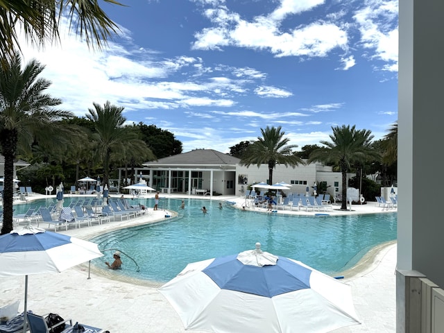 pool with a patio area and fence