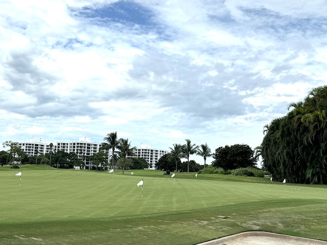 view of community with view of golf course and a lawn