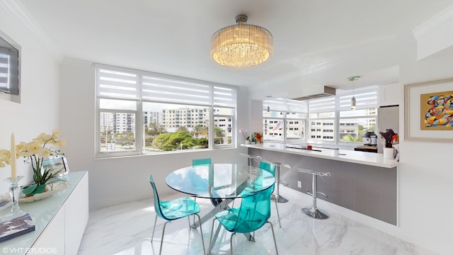 dining room featuring marble finish floor, a chandelier, and crown molding