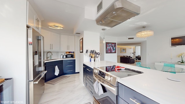 kitchen featuring visible vents, appliances with stainless steel finishes, a sink, ventilation hood, and blue cabinets