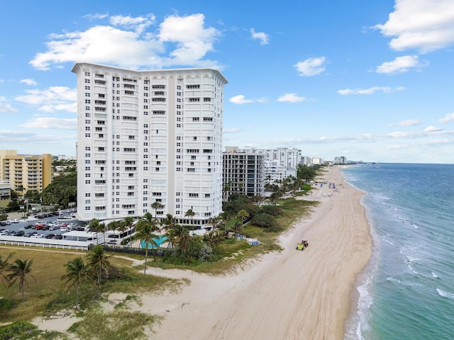 drone / aerial view featuring a view of city, a water view, and a view of the beach