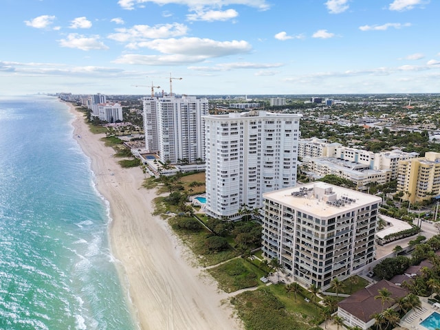 drone / aerial view featuring a view of the beach, a city view, and a water view