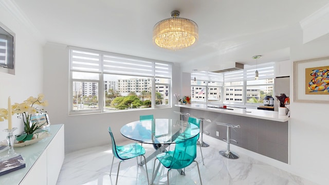 dining room featuring marble finish floor, a chandelier, and ornamental molding