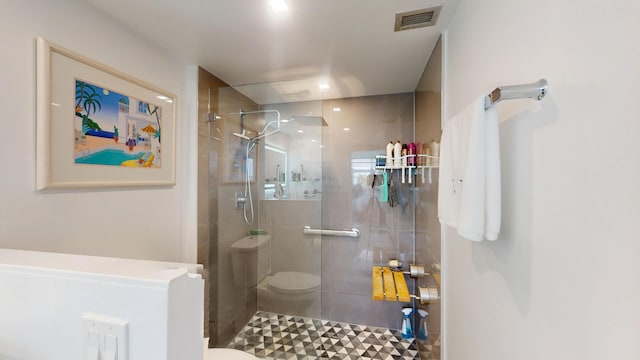 full bath featuring toilet, visible vents, and tiled shower