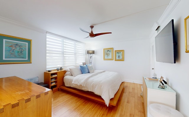 bedroom with crown molding, a ceiling fan, and light wood-style floors