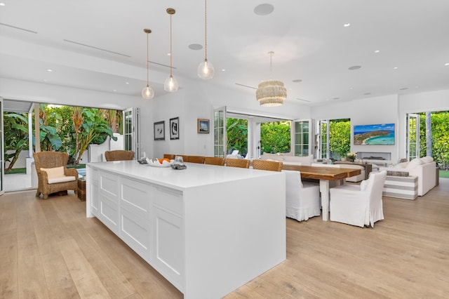 kitchen with open floor plan, light wood-style flooring, and white cabinetry