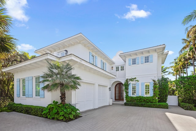 view of front of property with a garage, decorative driveway, and stucco siding